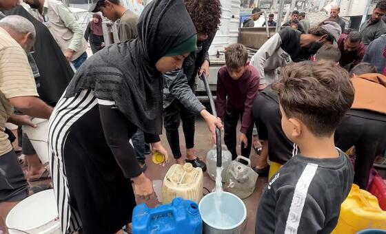 في غزة، يتجاوز البقاء على قيد الحياة مجرد الدخل. تصطف النساء والأطفال لساعات تحت أشعة الشمس لجمع مياه الشرب الآمنة، وهو واقع يومي في مخيمات النازحين.